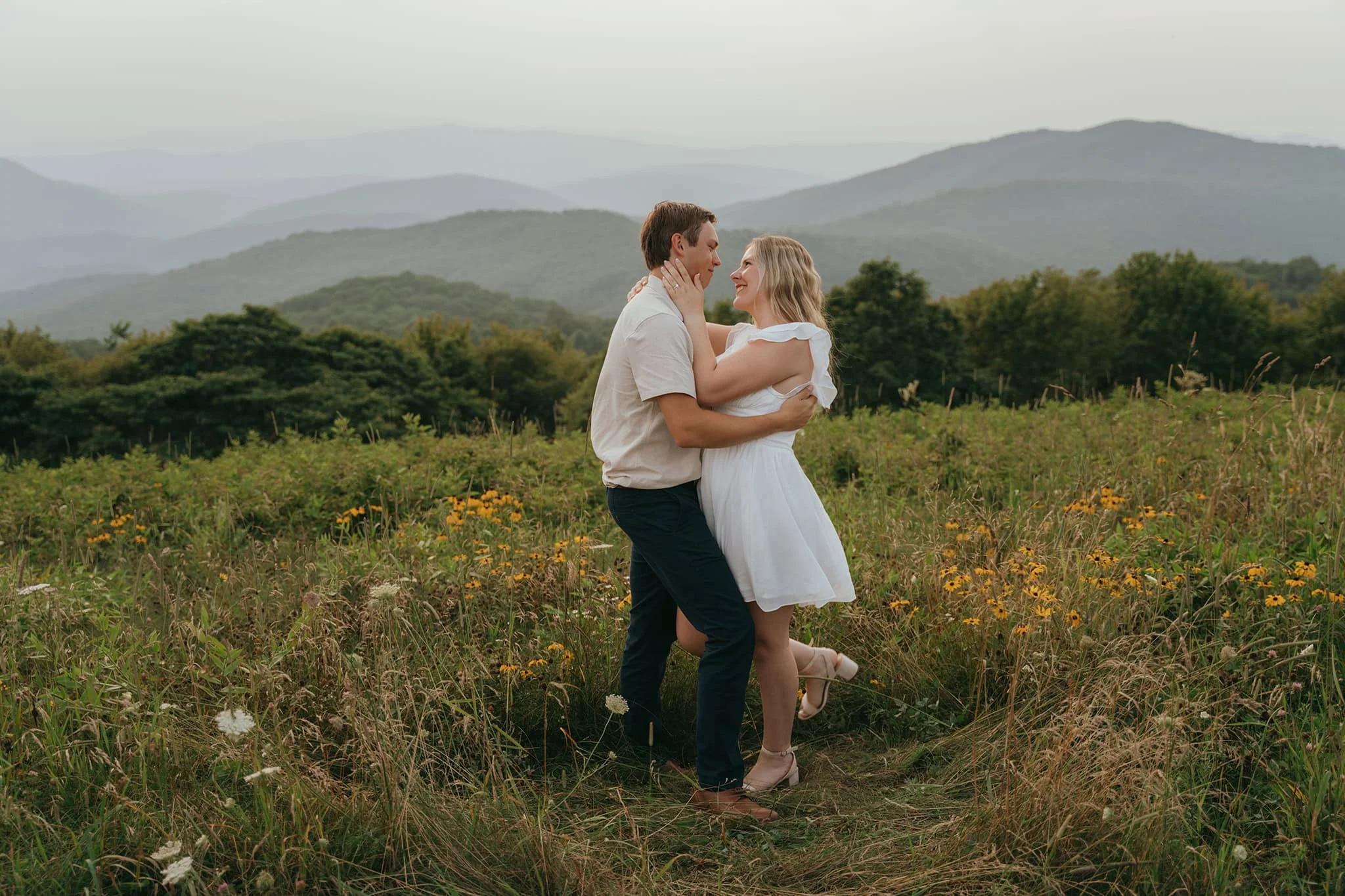 Romantic Smoky Mountains Proposal Portrait Couple embracing in a wildflower field with Smoky Mountains views during romantic proposal session