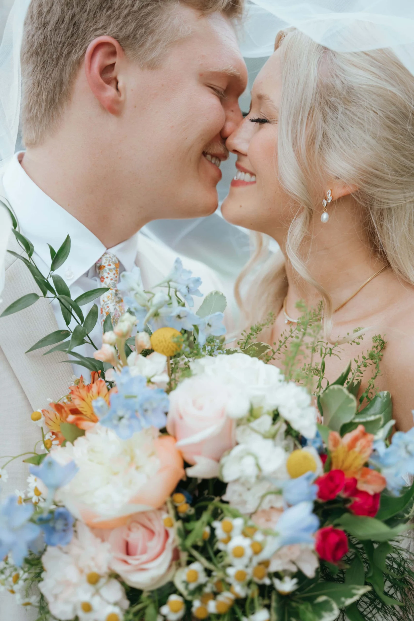 Newlyweds Meadow and Colston sharing a kiss at their outdoor summer ceremony