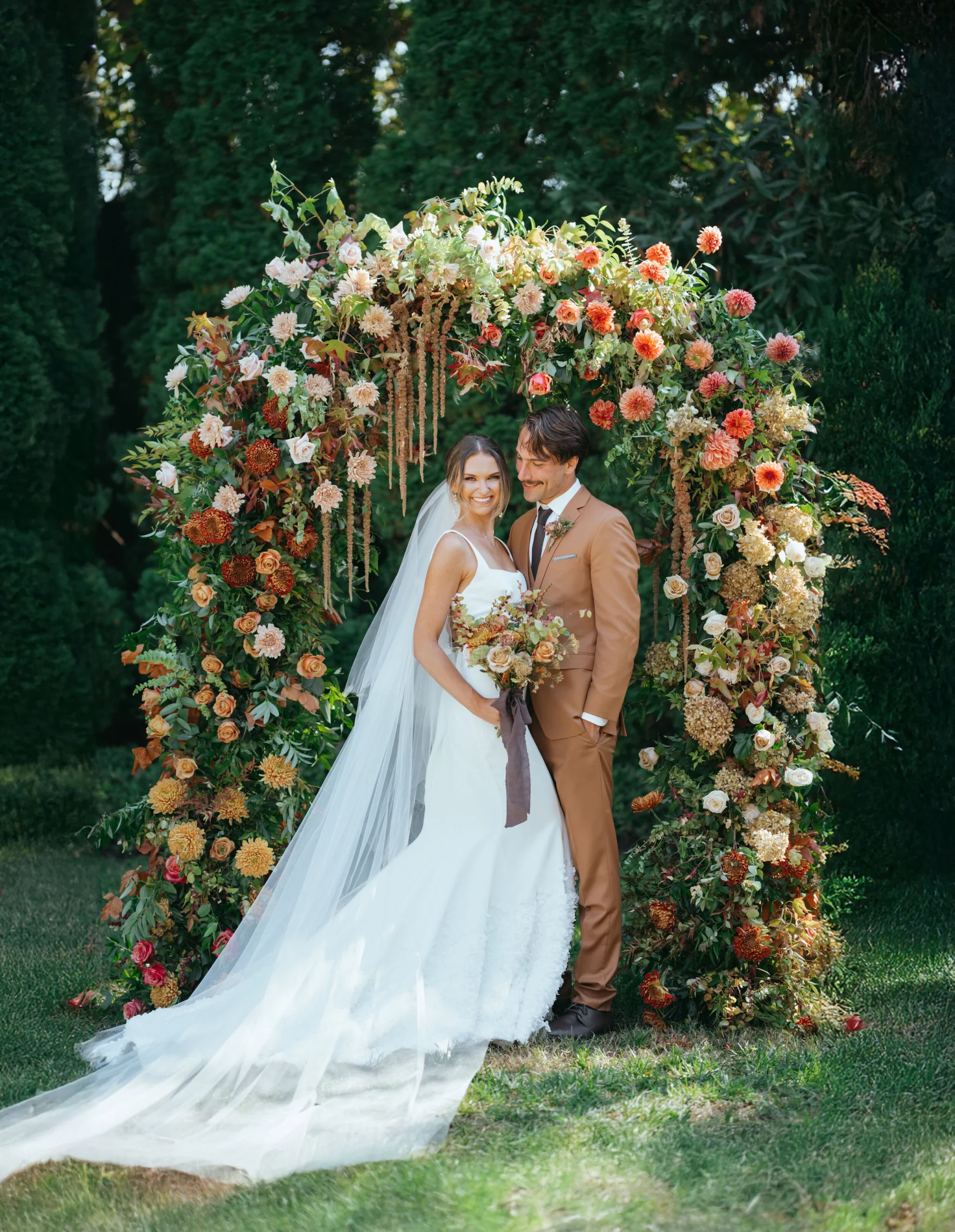 Couple taking bridal photos under the floral arch in Nashville wedding venue in TN