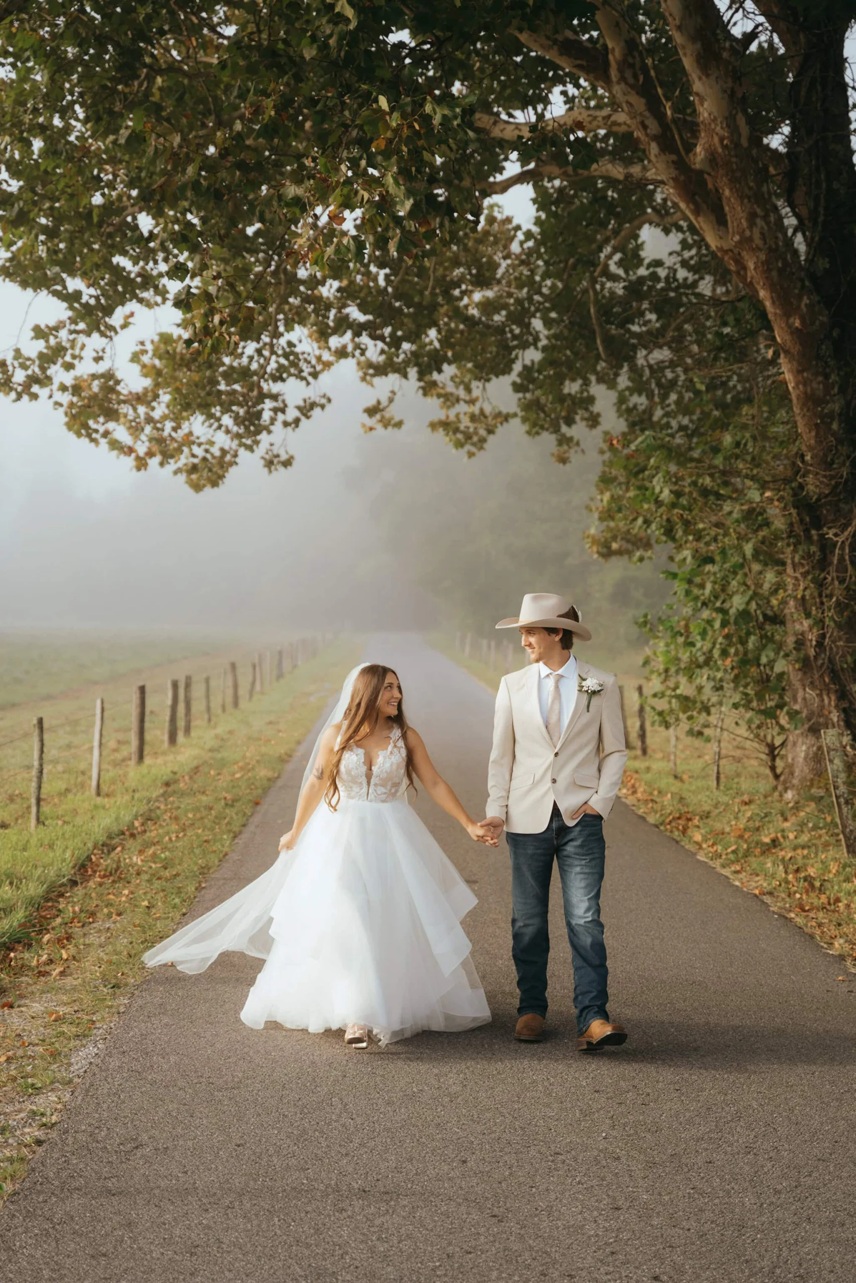 Newly weds are walking through Cades Cove after their sunrise Elopment at Cades Cove in Tennessee
