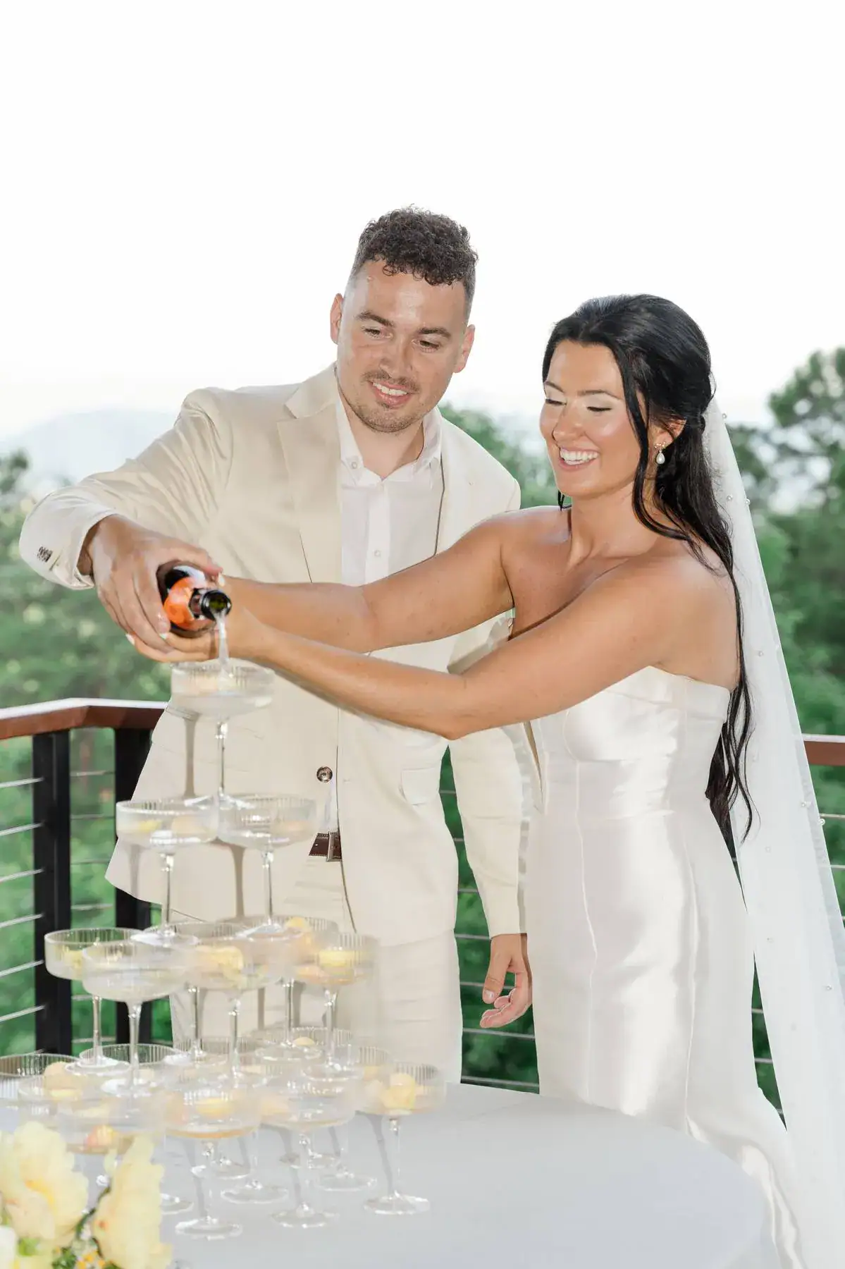 Wedding champagne tower Couple is having fun with champagne before wedding reception